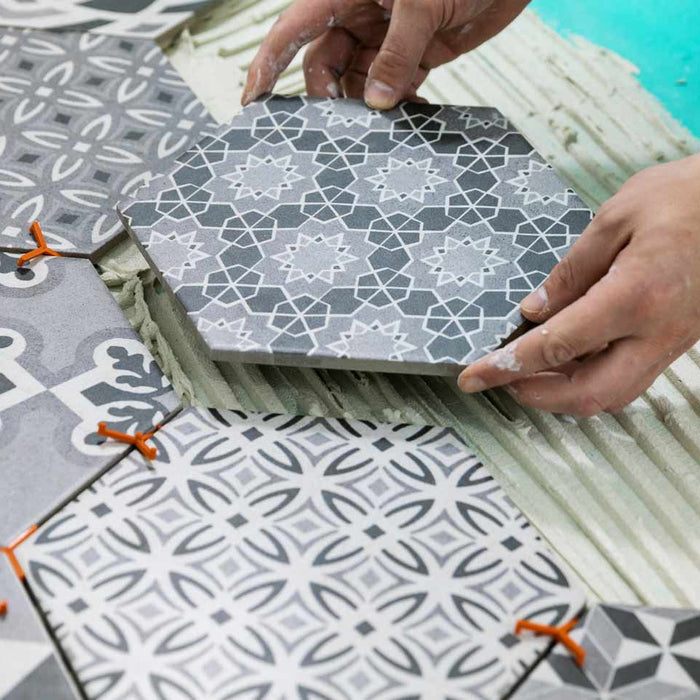 hexagon tiles being fitted on a floor with adhesive