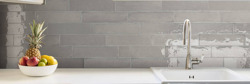 Image of laurel grey wall tiles as a kitchen splash back with tap and sink and fruit bowl on work top