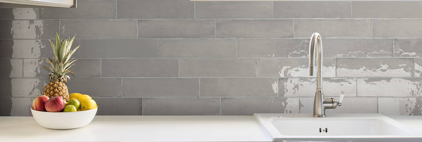 laurel grey wall tiles as a kitchen splash back with tap and sink and fruit bowl on work top