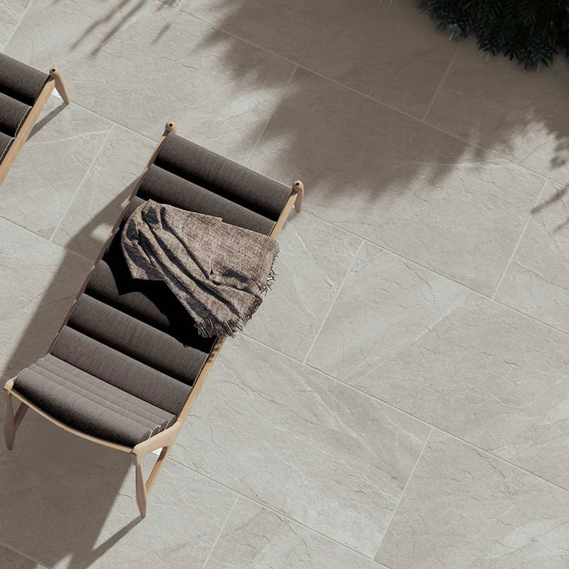 Image of Outdoor Porcelain tile 60x120cm Hailes Taupe patio with brown sun loungers on it.