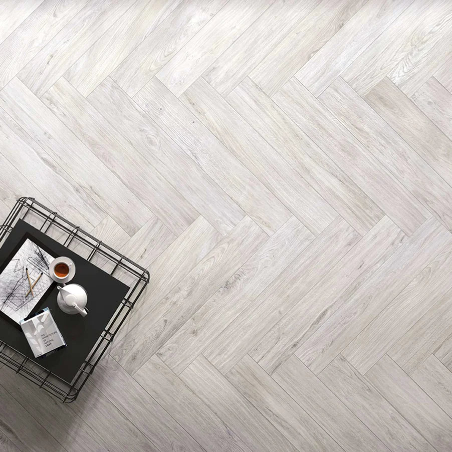 Image of Softwood grey wood effect tile 20x120cm in herringbone tile pattern with black metal tray holding teapot and doodles.