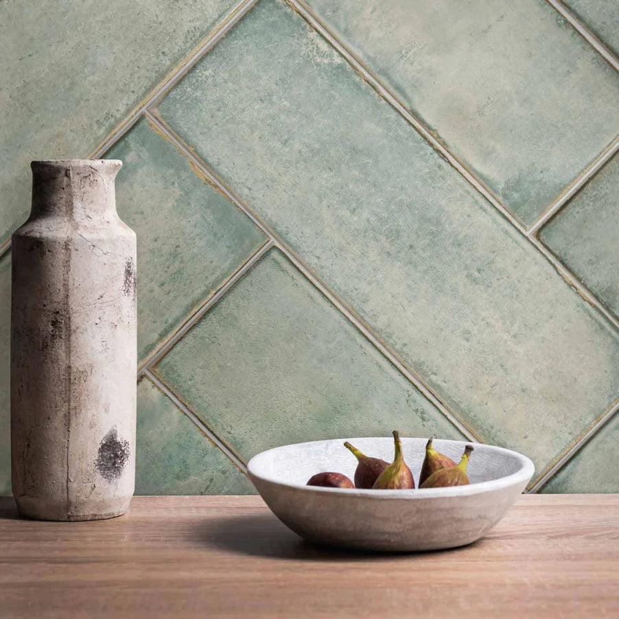   Click to expand Montblanc Sage Tile Original Style Tileworks in a herringbone pattern. Wooden table with pears in a white bowl and grey bottle. 