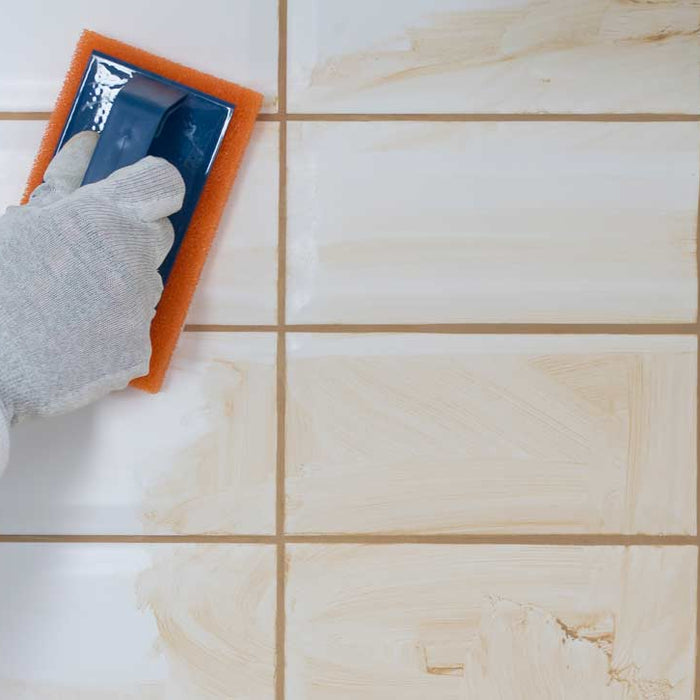 white tiles with beige grout being cleaned off tiles