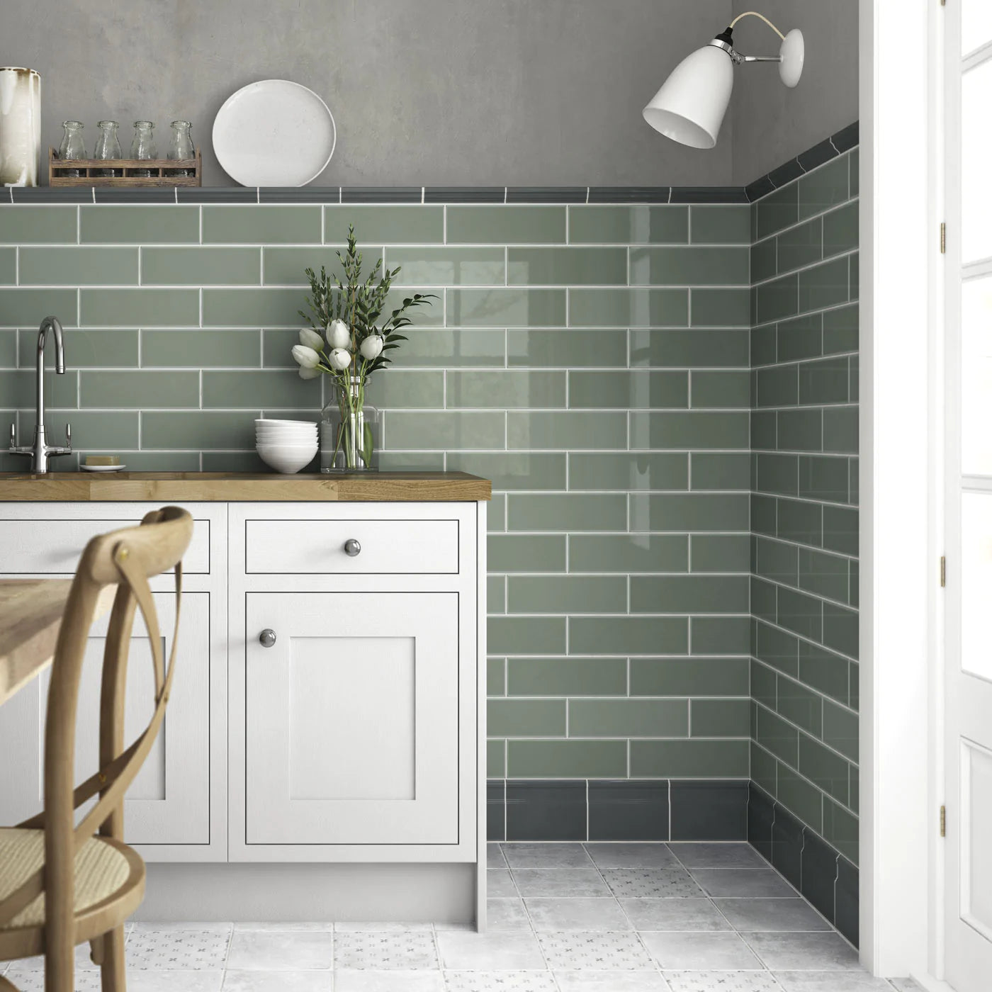10x30cm Savoy Sage gloss wall tile half tiled wall in a cottagecore kitchen setting with white farmhouse kitchen cabinets, wooden worktop, vase of flowers and wooden kitchen chair