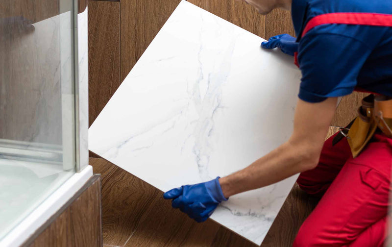 Image of tiling holding marble tile against bathroom floor with wood effect tiles