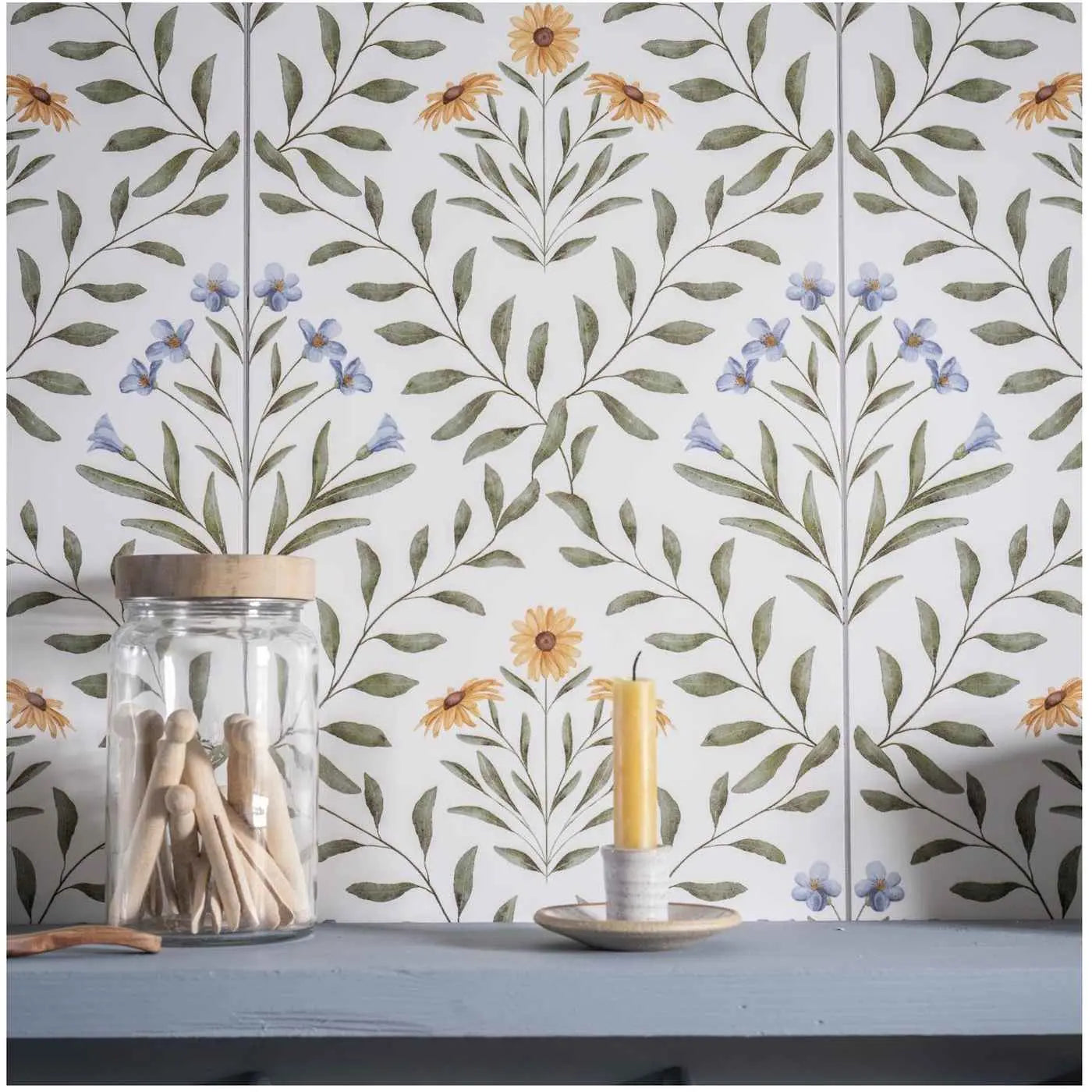 Image of Floral tile backsplash with a jar of wooden pegs and a small candle on a blue shelf.