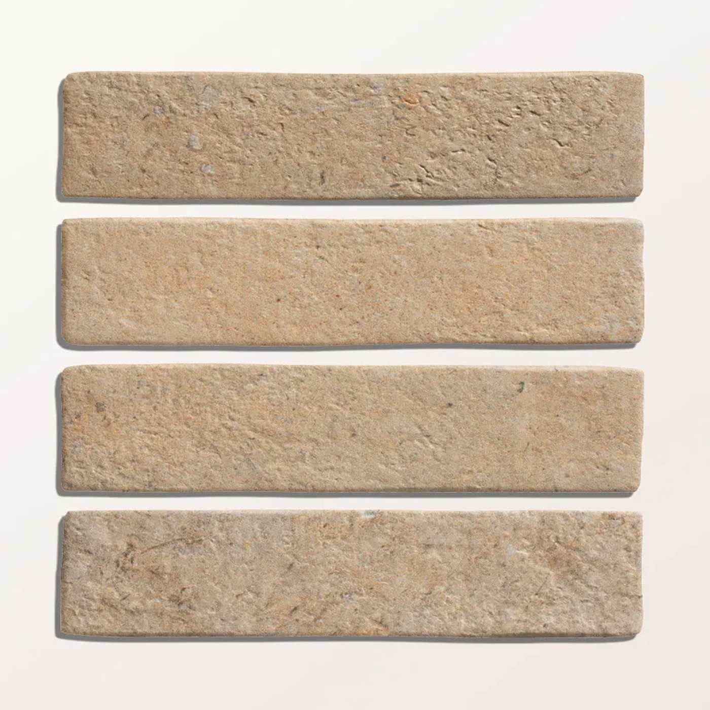 Image of Four rectangular beige stone tiles with a textured, natural surface, arranged vertically on a light off-white background.