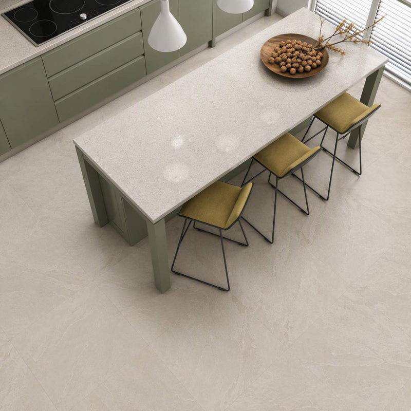 Image of A modern kitchen island with a light beige stone-look countertop and matching light beige flooring, surrounded by olive green chairs with yellow-green upholstered seats. A bowl of nuts sits on the counter, and pendant lights hang above.