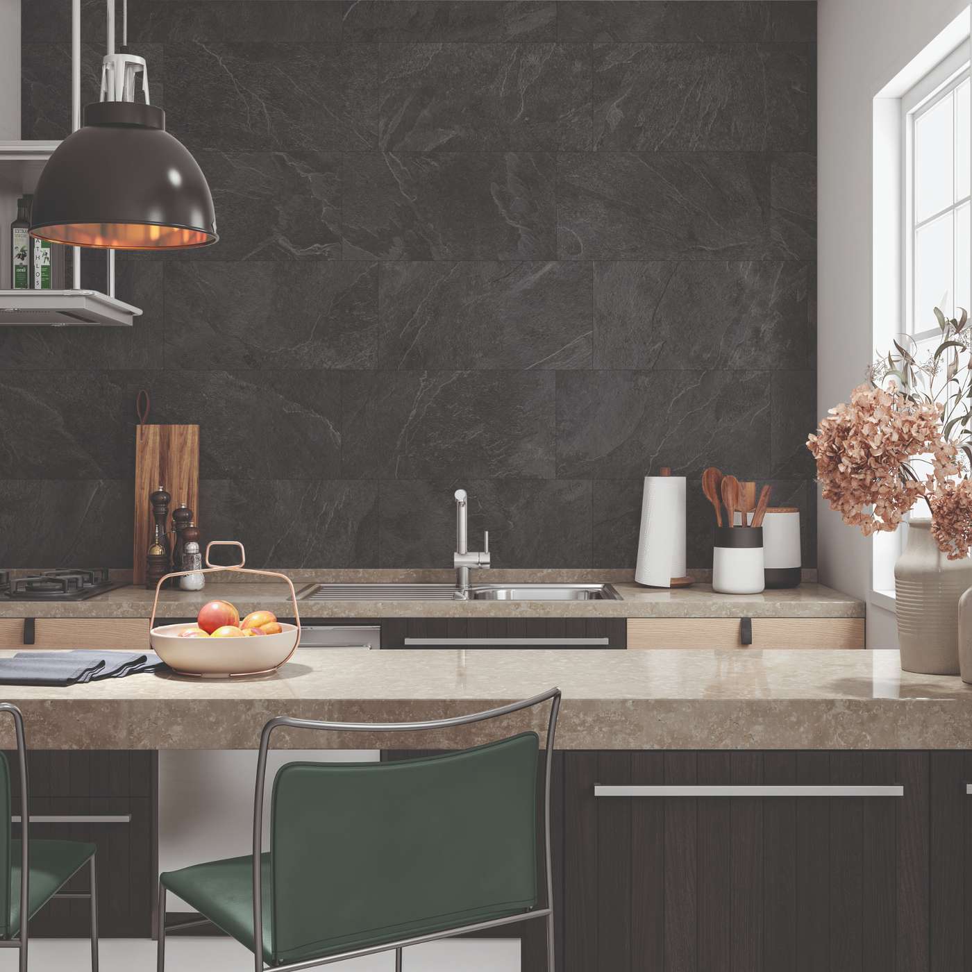 Image of A modern kitchen interior with a dark charcoal stone backsplash, light beige stone countertops, dark wood cabinets, a green upholstered chair, a black pendant lamp, and decorative dried flowers by a window.