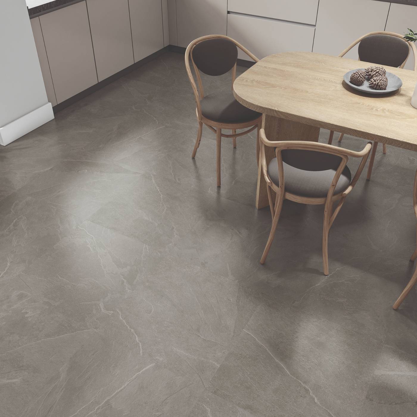 Image of Gray stone-look floor tiles in a modern kitchen setting with a light wood dining table and chairs.