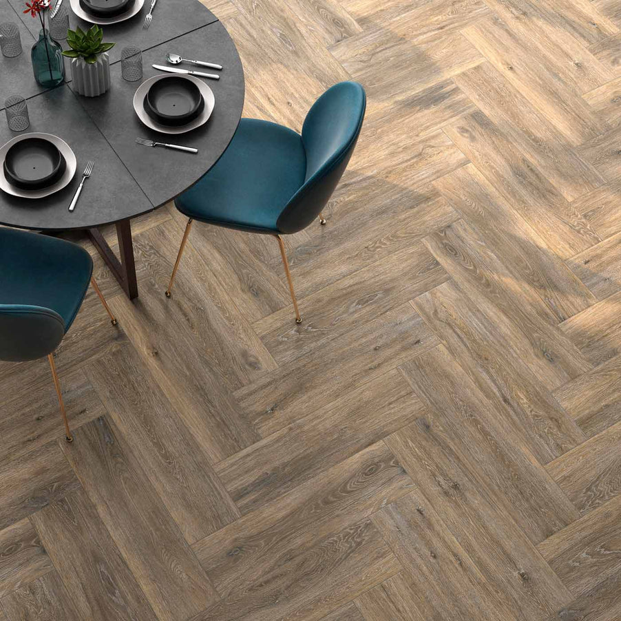 Heartwood Robal tiles 20x120cm, worn wood effect herringbone tiles with teal dining room chairs and grey round table with place settings ready.