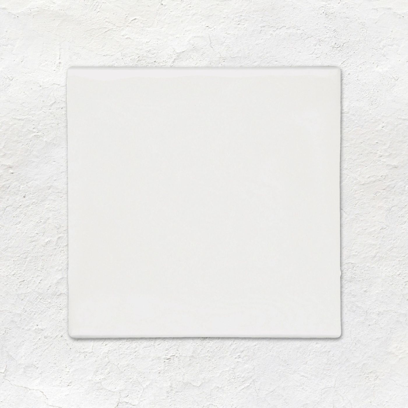 Image of A square white ceramic tile with a glossy finish, centered on a textured white plaster background.