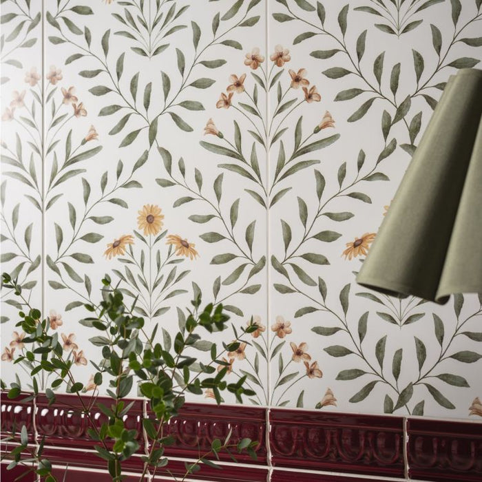 Floral patterned wall tiles with a red border and greenery in the foreground.