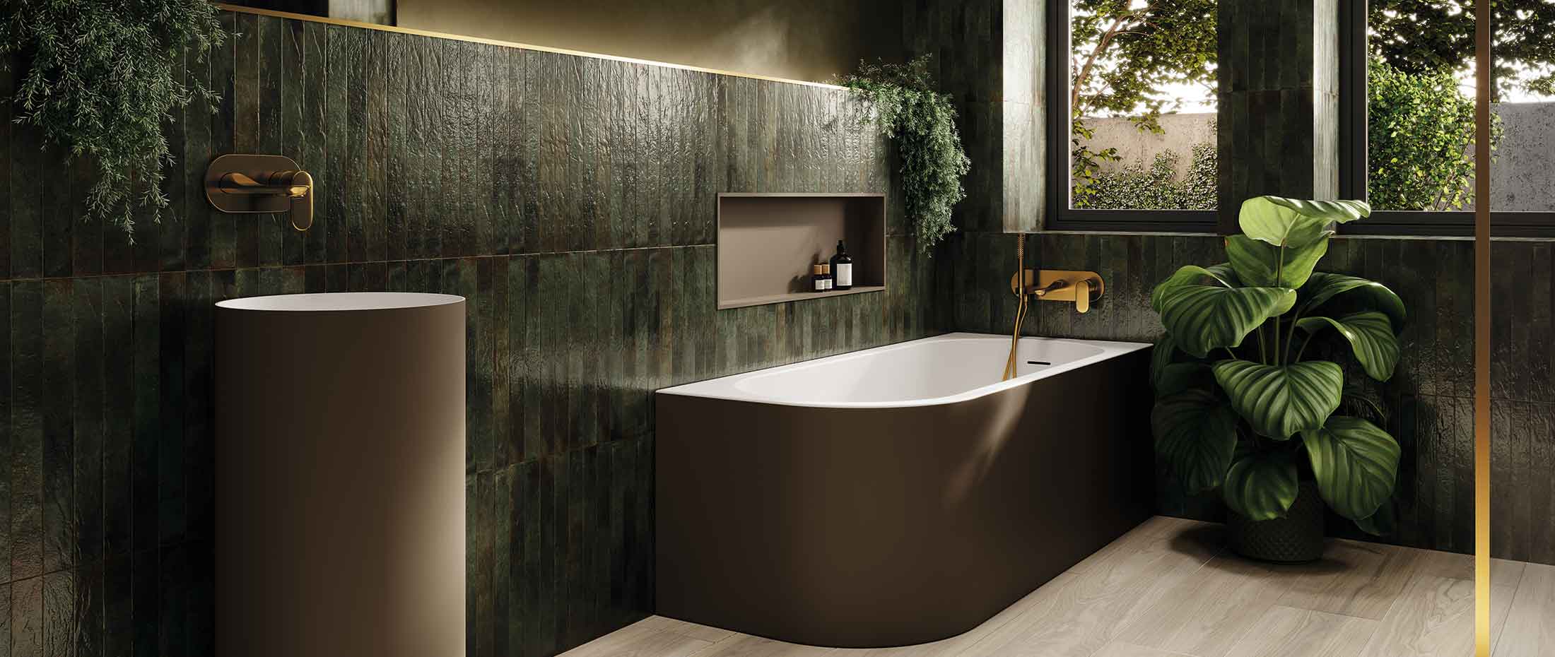 A modern freestanding bathtub in a dark brown finish with a white interior, set in a stylish bathroom with dark green textured tiles, a matching pedestal sink, and a large green plant.