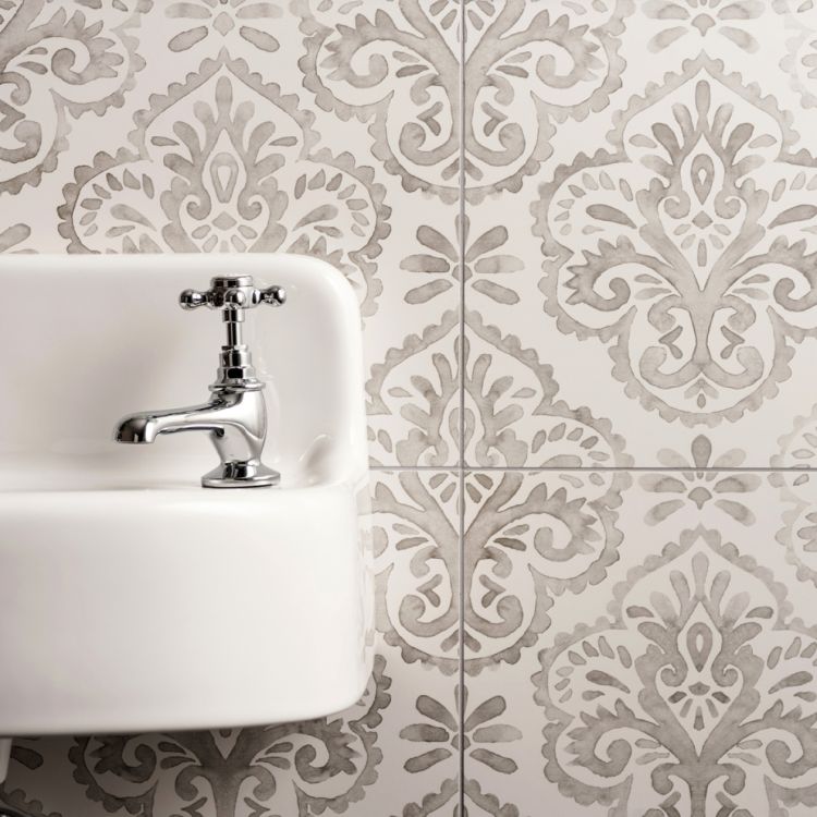 Image of White sink with silver faucet against a decorative tile wall