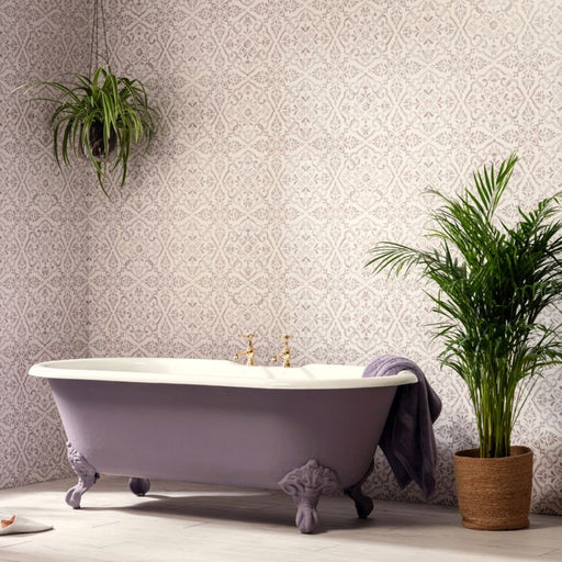 Purple freestanding bathtub in a bathroom with patterned wallpaper and plants.
