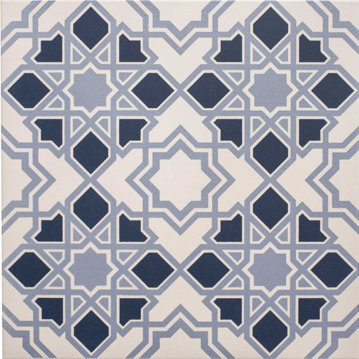 Square tile featuring a geometric star and diamond pattern in light and dark blue on a chalk‑coloured background.”