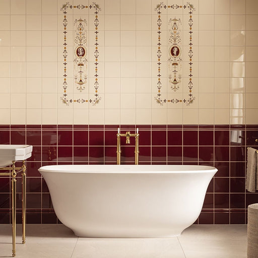Bathroom with a freestanding bathtub against a wall with decorative tiles.