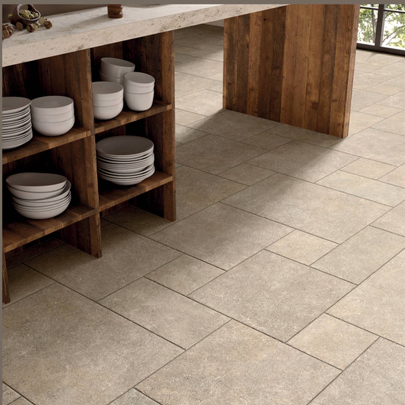 Image of Light beige stone-look rectangular floor tiles installed in a modern kitchen setting with a wooden counter and shelves holding white plates.