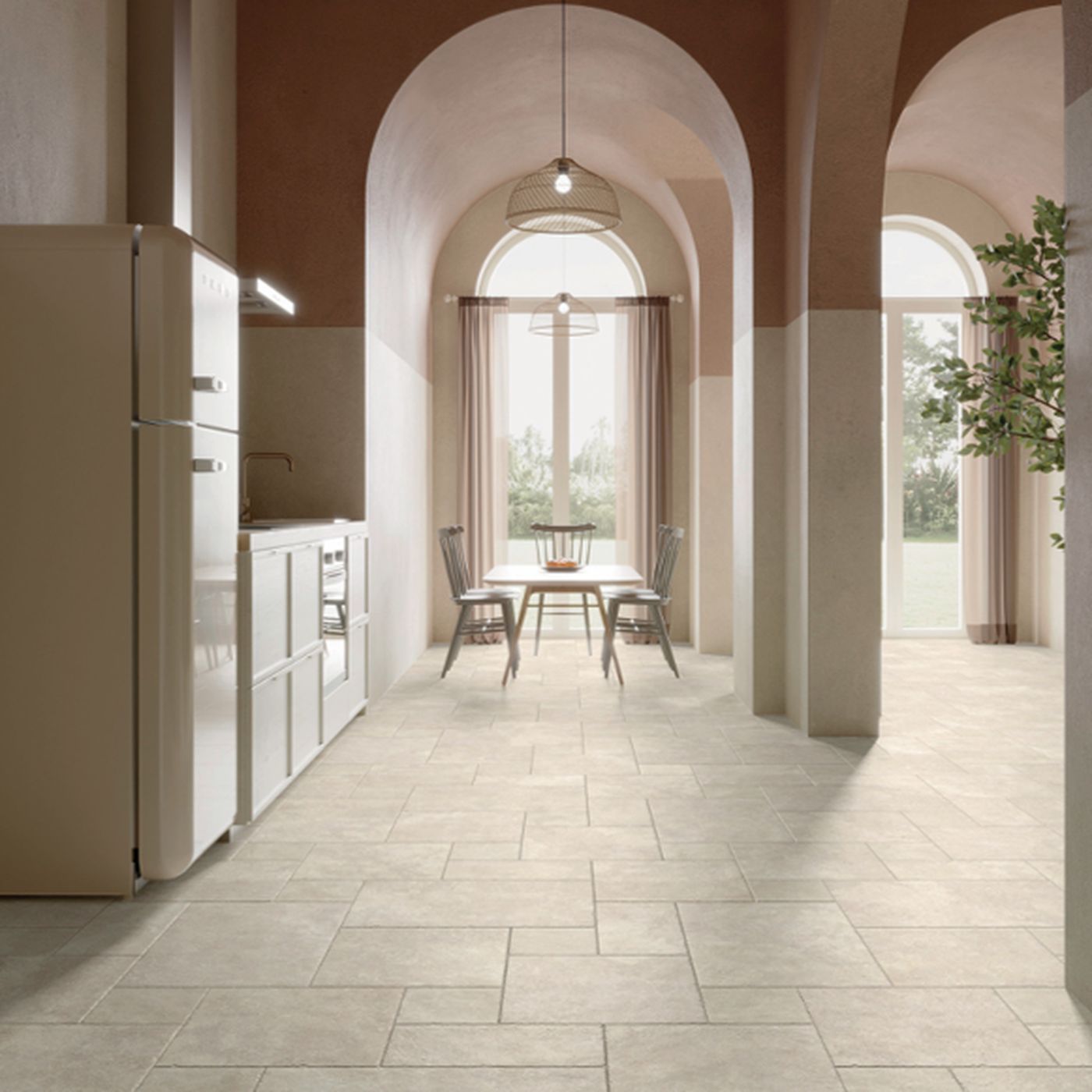 Image of A modern kitchen and dining area with white stone floor tiles, cream arches, white cabinetry, and a large refrigerator on the left.