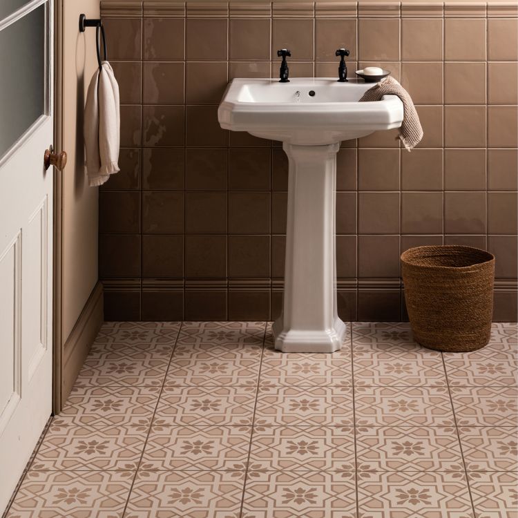 Image of Bathroom with a white pedestal sink against a tiled wall.