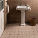 Bathroom with a white pedestal sink against a tiled wall.
