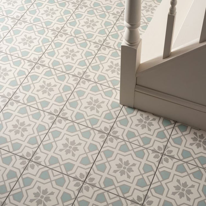 Patterned tiles on a floor with a chair leg visible
