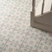 Patterned tiles on a floor with a chair leg visible