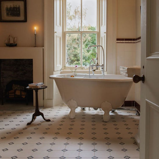 Bathroom with a freestanding bathtub near a large window, featuring a fireplace and decorative elements.