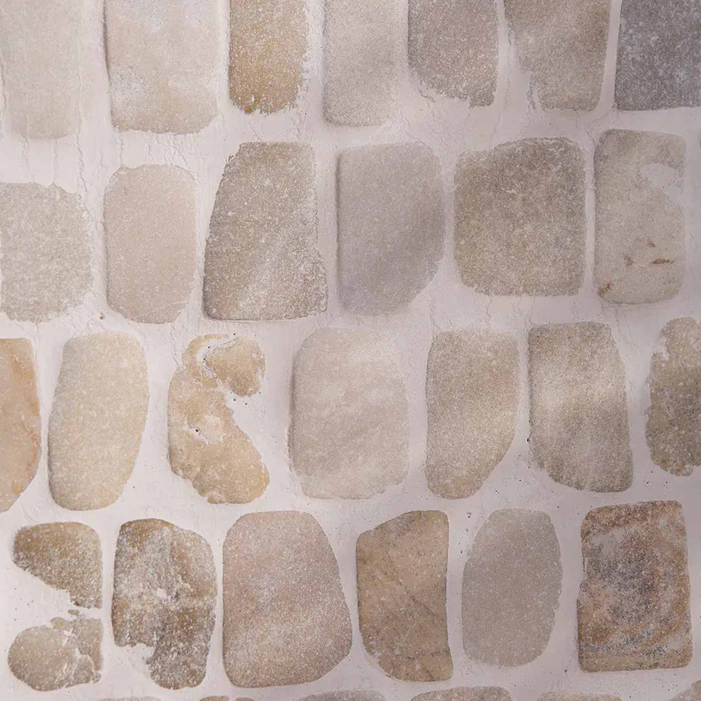 Image of Beige and light brown stone mosaic tile pattern with irregular rounded shapes arranged in a grid on a light background.