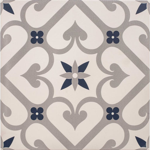 Square tile with a grey and dark blue floral and scrollwork pattern on a chalk‑coloured background