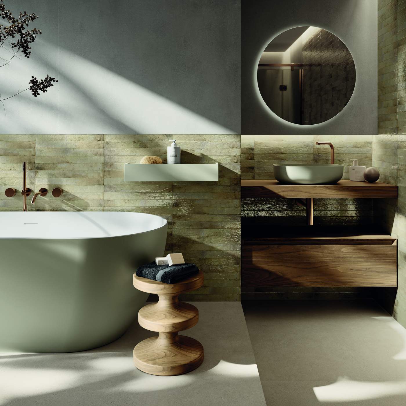 Image of Bathroom with beige rectangular wall tile wall behind a sage green freestanding bath, round backlit mirror above a walnut vanity with sage green countertop basin, copper taps and fittings