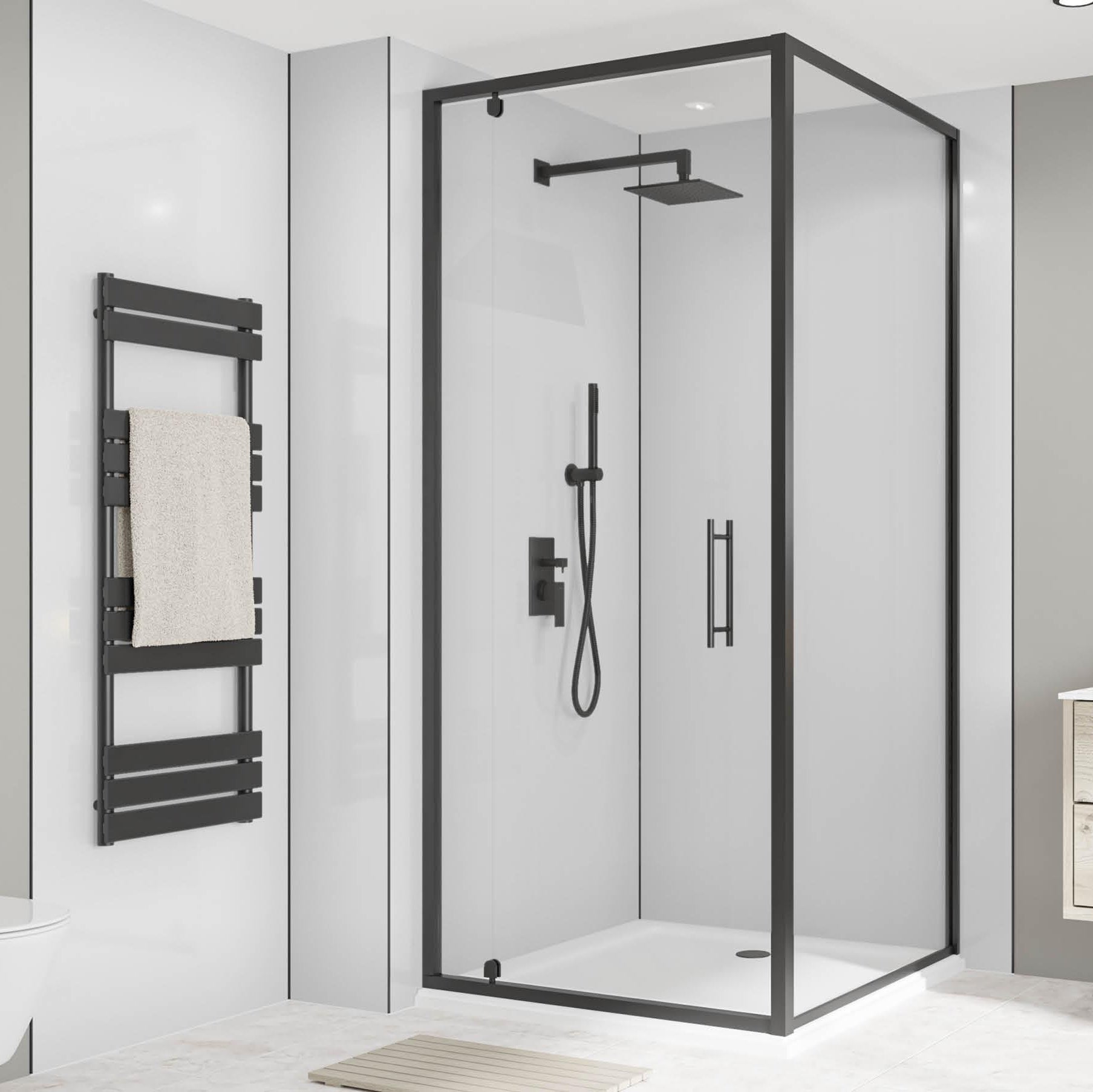 Image of A modern frameless glass shower enclosure with black metal framing, shown installed in a contemporary bathroom with a floating vanity, mirror, and towel rail.