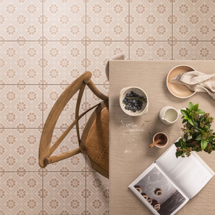 Image of Dining table with a chair, bowls, a plant, and an open book on a tiled floor.