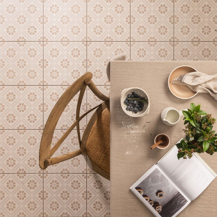 Dining table with a chair, bowls, a plant, and an open book on a tiled floor.