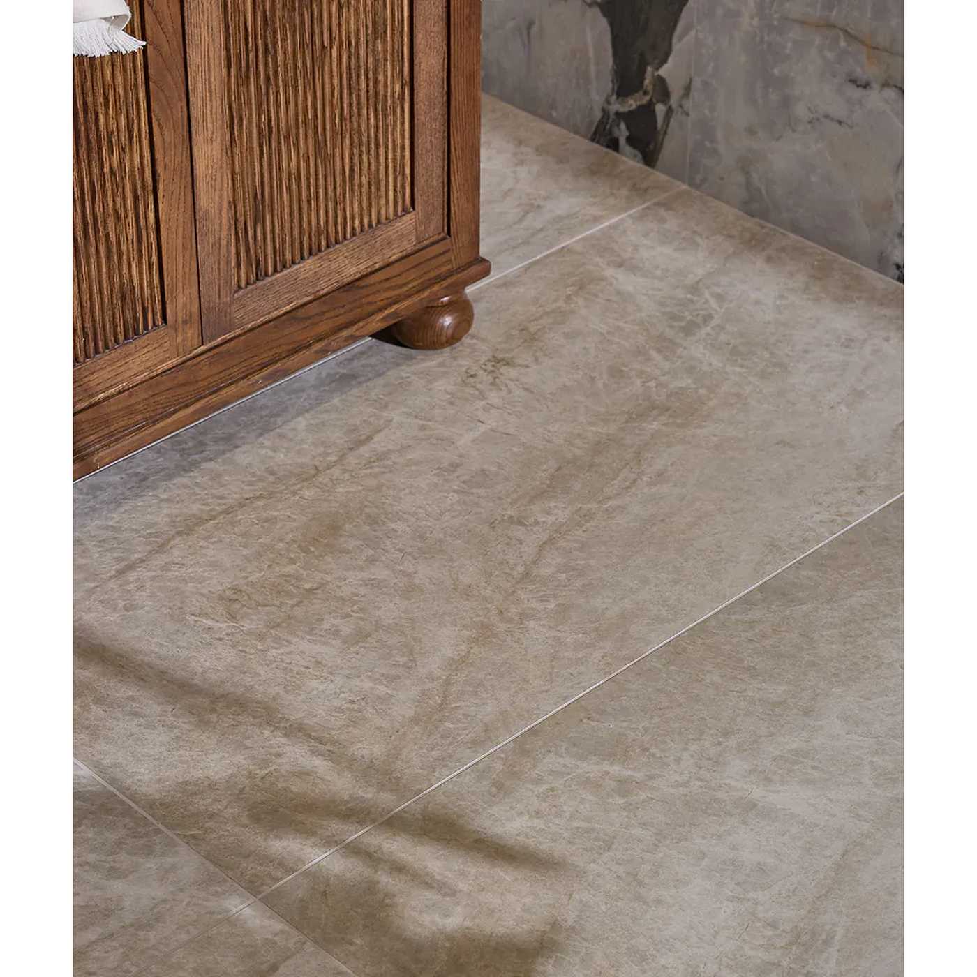 Image of Beige marble-look floor tiles with a subtle natural stone texture, shown installed in a room corner next to a wooden cabinet.