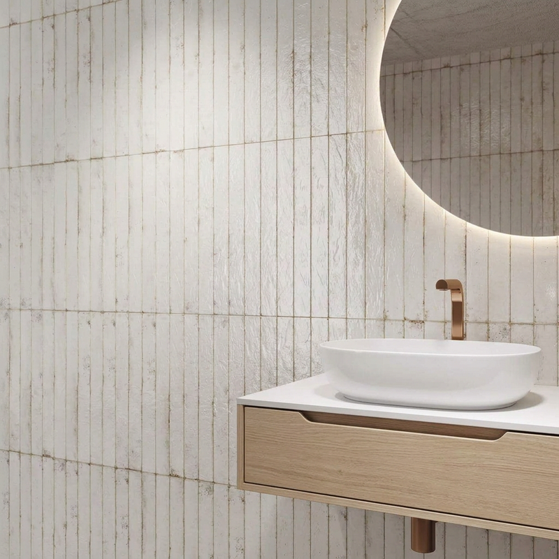 Image of Calle White textured tiles in a bathroom with a pale-oak vanity, white oval basin and soft ambient lighting