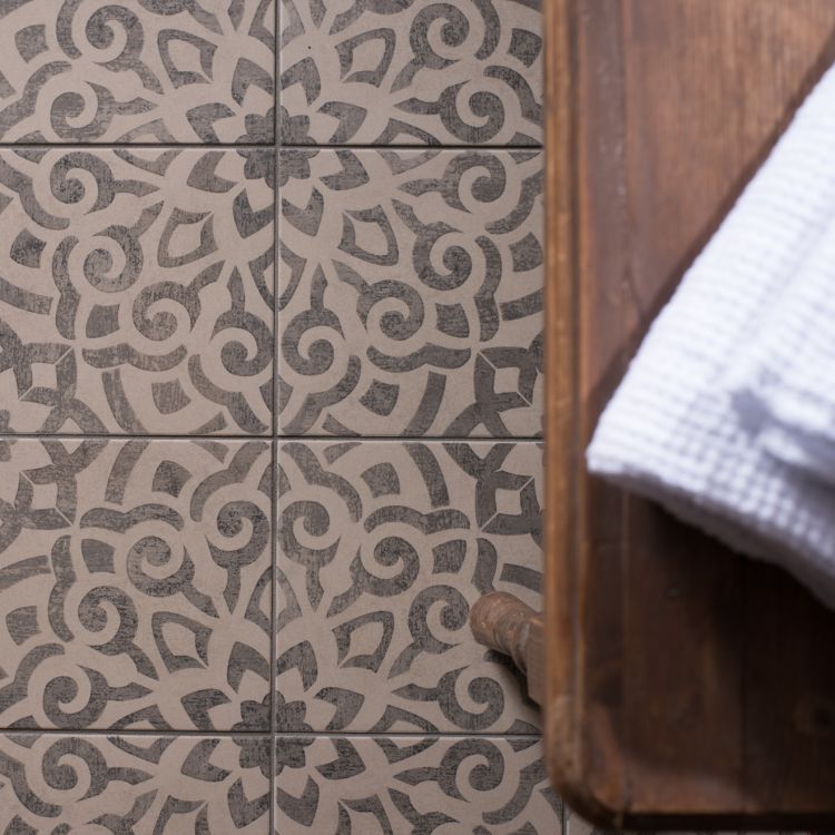 Image of Patterned tiles with a wooden floor and white towel in the corner