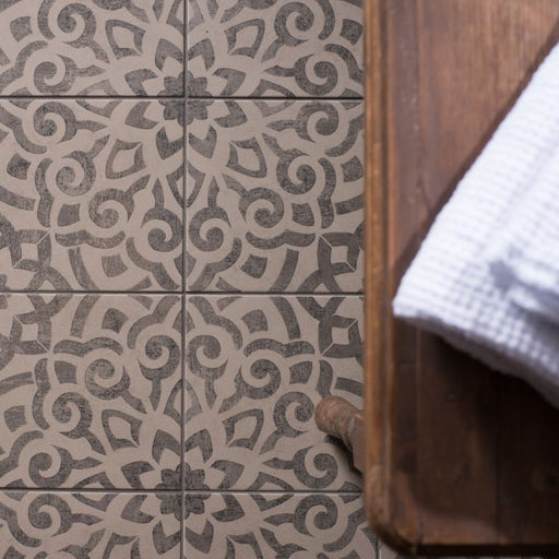 Patterned tiles with a wooden floor and white towel in the corner