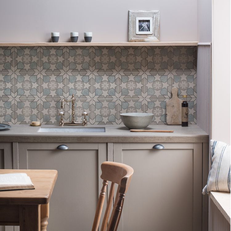 Image of Kitchen with patterned backsplash, sink, and wooden chair.