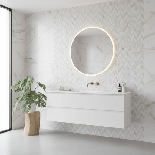 Modern white floating bathroom vanity with a circular illuminated mirror, patterned feature wall, and a potted plant in a bright minimalist bathroom.