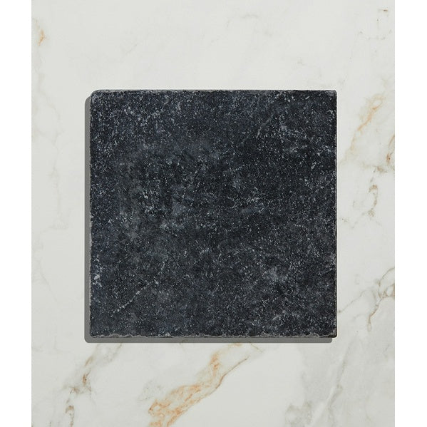 Black square stone coaster on a marble surface