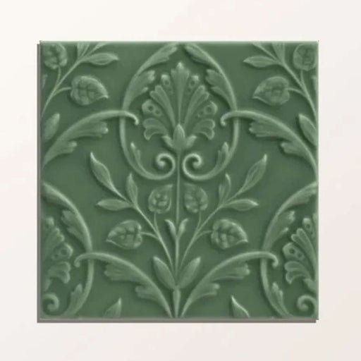 Decorative green tile with floral pattern on a white background