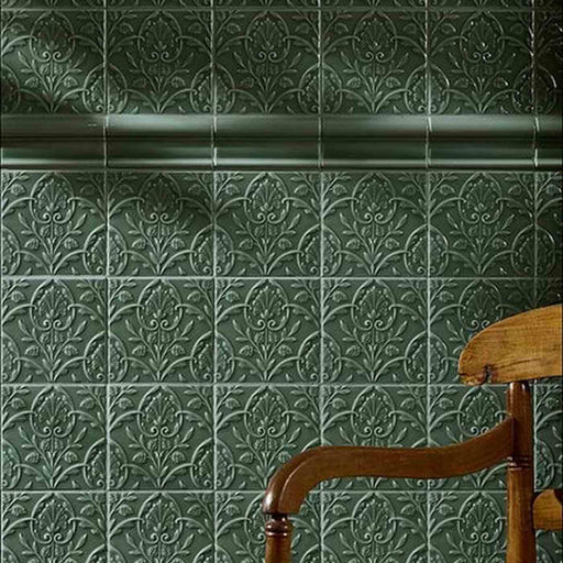 Dark green Victorian-style embossed tiles with an ornate vine pattern and decorative moulding.
