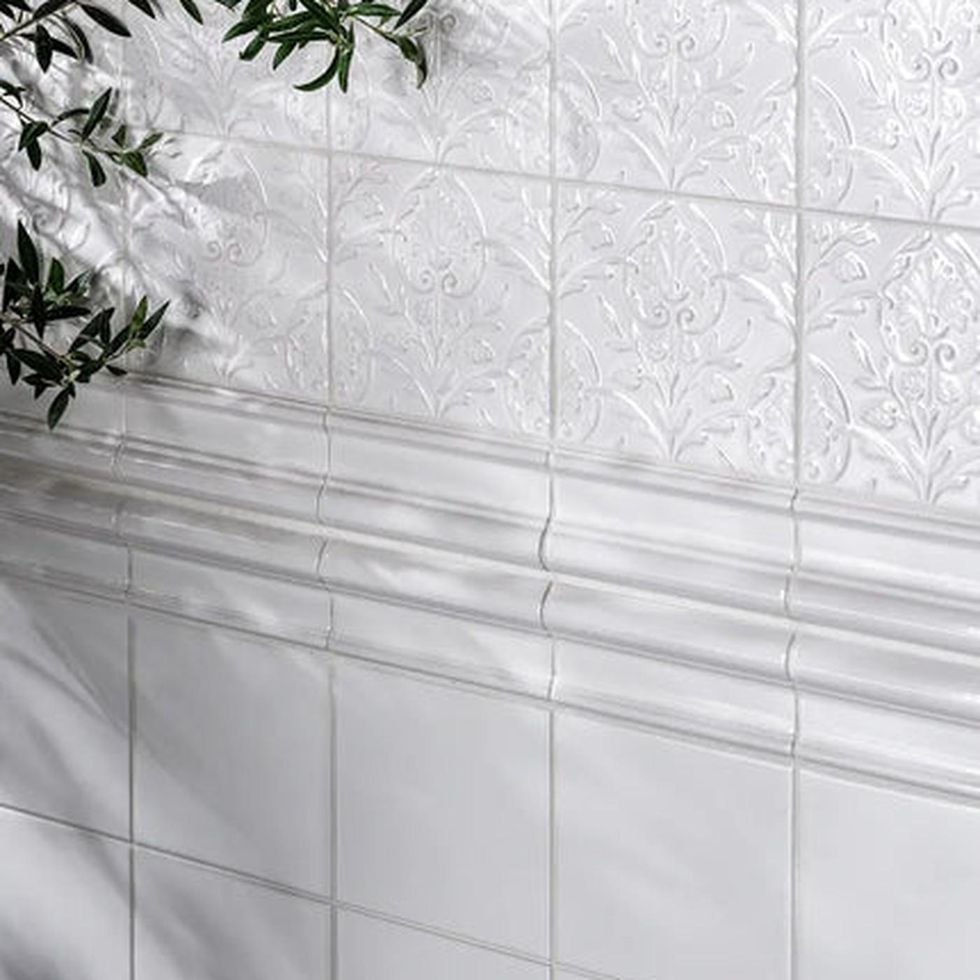 Image of wall with small white square patterned tiles, white border tiles and plain white tiles below