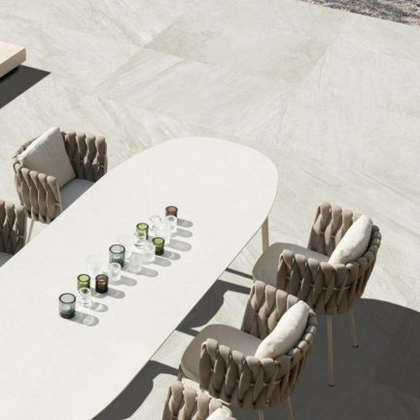 Image of Modern outdoor dining set with a long table and chairs on a concrete patio.