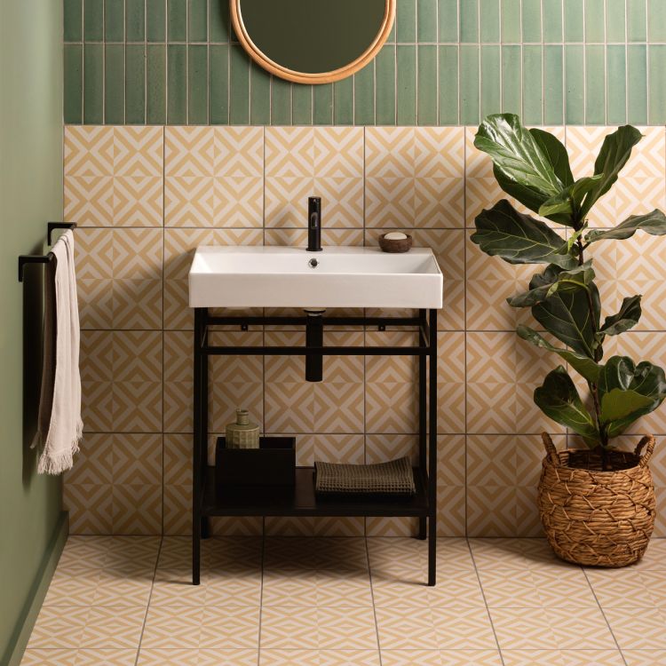 Image of Small bathroom with a white sink, patterned tiles, green wall tiles, and a potted plant.