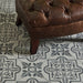 Brown leather ottoman on a patterned tile floor
