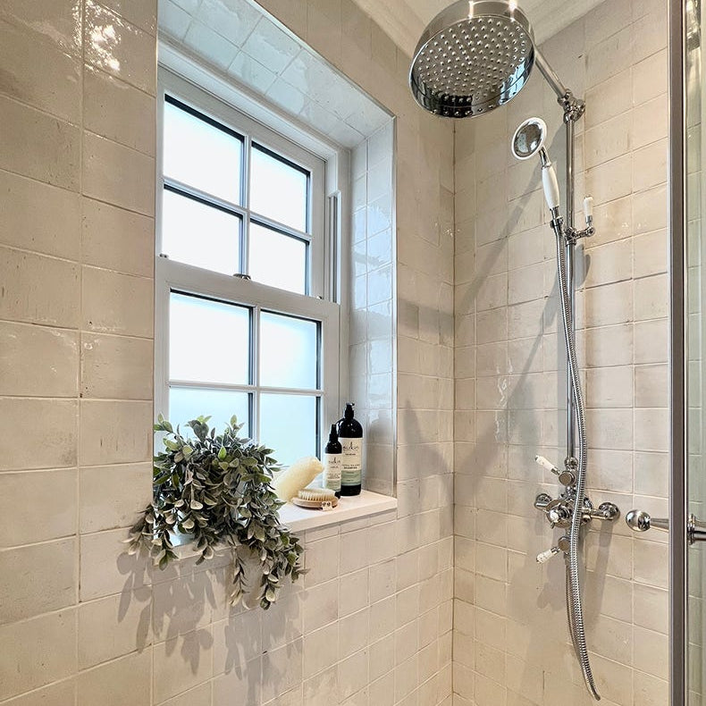 Image of Shower area with pottery porcellain natural cotton tiled walls, a window, and bathroom products.