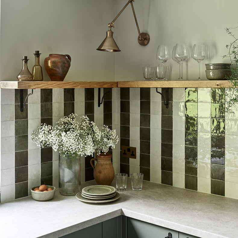 Image of Modern kitchen with green and white tiled backsplash, wooden shelves, and decorative items.